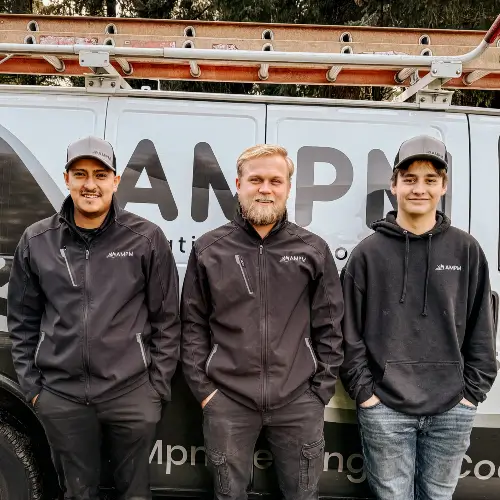 Service technicians from AMPM Heating and Cooling standing side-by-side in front of a work van with the AMPM logo