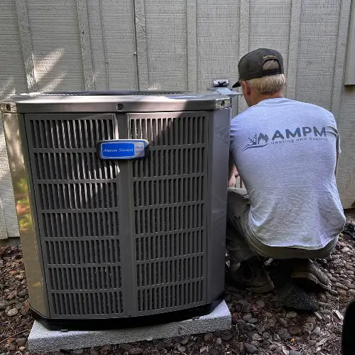 Service technicians from AMPM Heating and Cooling performing maintenance on an Air Conditioning unit