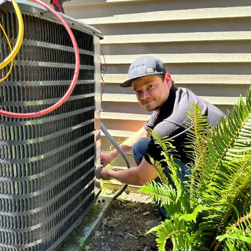 Service technician from AMPM Heating and Cooling inspecting and tuning an air conditioning system