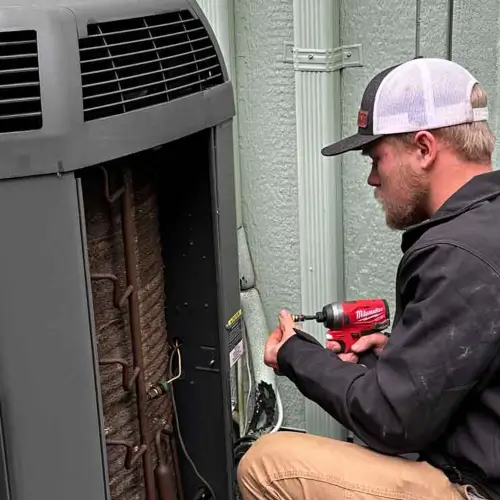 AMPM Heating and Cooling technician doing maintenance on a residential air conditioning unit